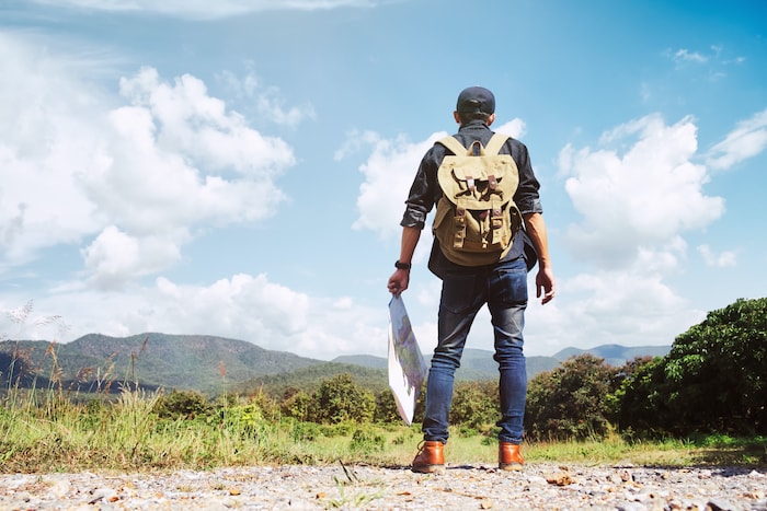 Young Man Traveler with backpack relaxing outdoor.